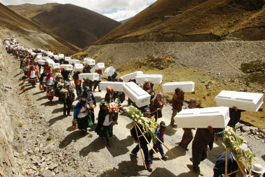 Imagen de familiares de víctimas muertas en masacre cargan ataúdes durante una ceremonia de reentierro