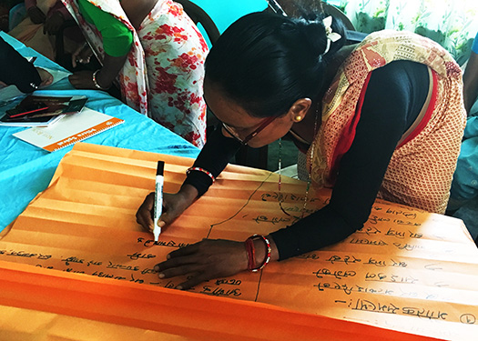Image of a Nepalese victim writing names of other victims on a wooden board